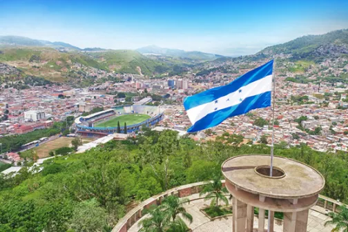 The Honduran flag flying over Tegucigalpa from a hilltop overlook