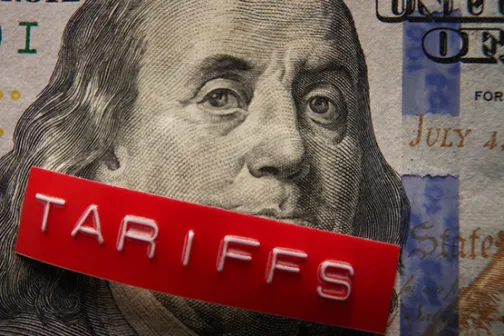 A red 'TARIFFS' block covering Benjamin Franklin's mouth on a $100 bill